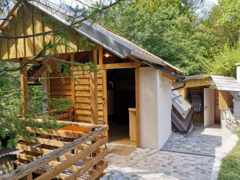 un edificio con porche y parrilla en Glamping Narnia en Bovec