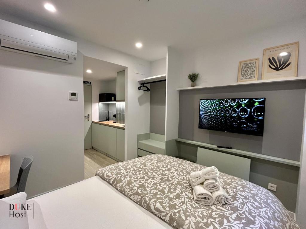 1 dormitorio con 1 cama y TV de pantalla plana en Duke Vallehermoso Apartament, en Madrid