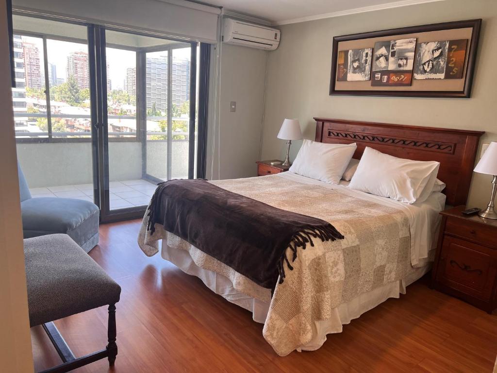 Un dormitorio con una cama grande y una ventana en Isabel Suites Vitacura, en Santiago