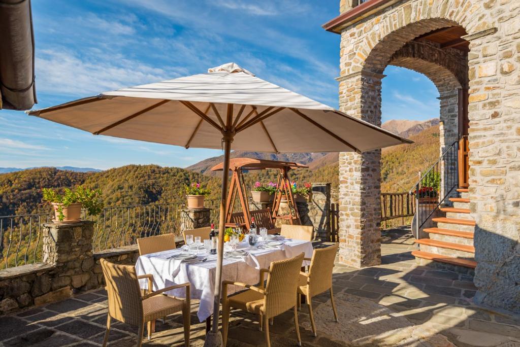 a table with an umbrella on a patio at Vivi Luxury Country House in Comano