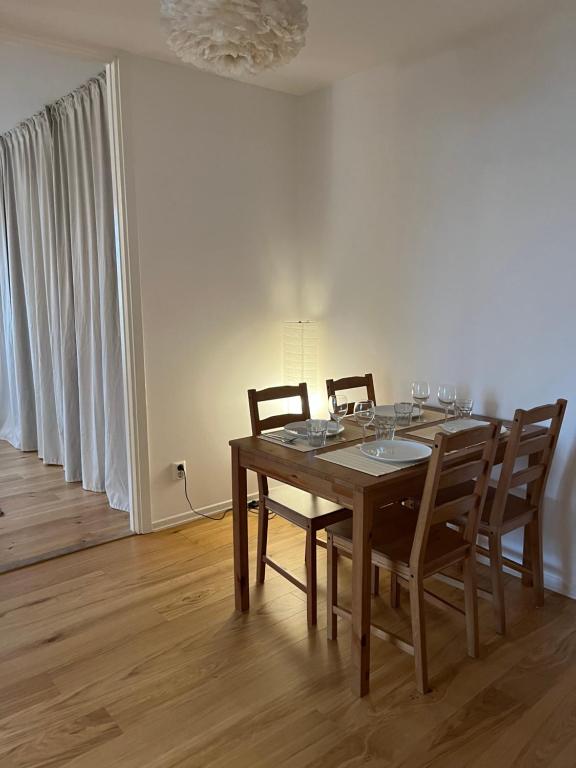 mesa de comedor con 4 sillas y lámpara de araña en Sky view apartment, Stockholm, en Solna