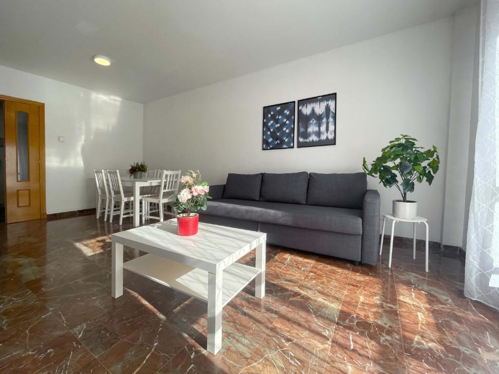 sala de estar con sofá y mesa en Apartamentos El Pilar Suites 3000 en Zaragoza