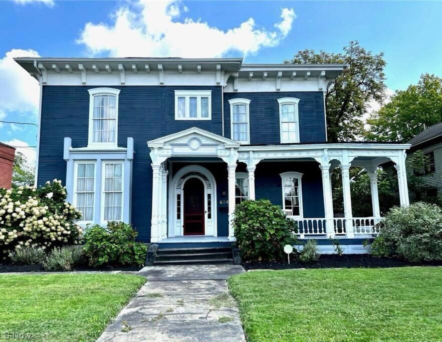 niebieski dom z białą werandą w obiekcie Luxurious Historic Victorian w mieście Warren
