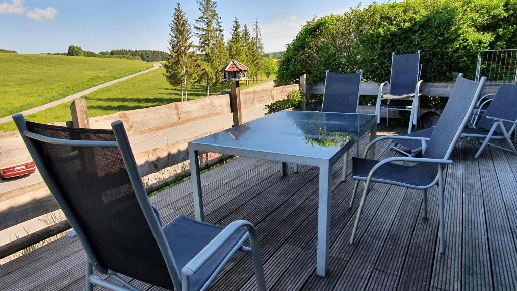 - une table et des chaises sur une terrasse avec un nourrisson d'oiseaux dans l'établissement Lechbruck am See Feriendorf Hochbergle Haus 7, à Lechbruck am See