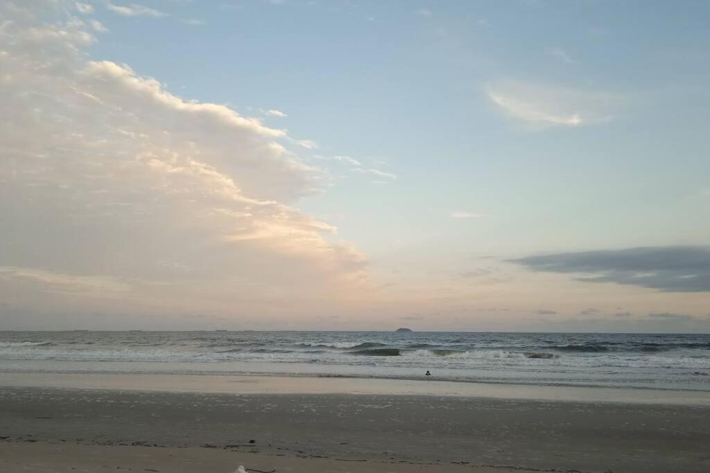 una playa con un cielo nublado y el océano en Lindo Apto com vista para o Mar! en Pontal do Paraná