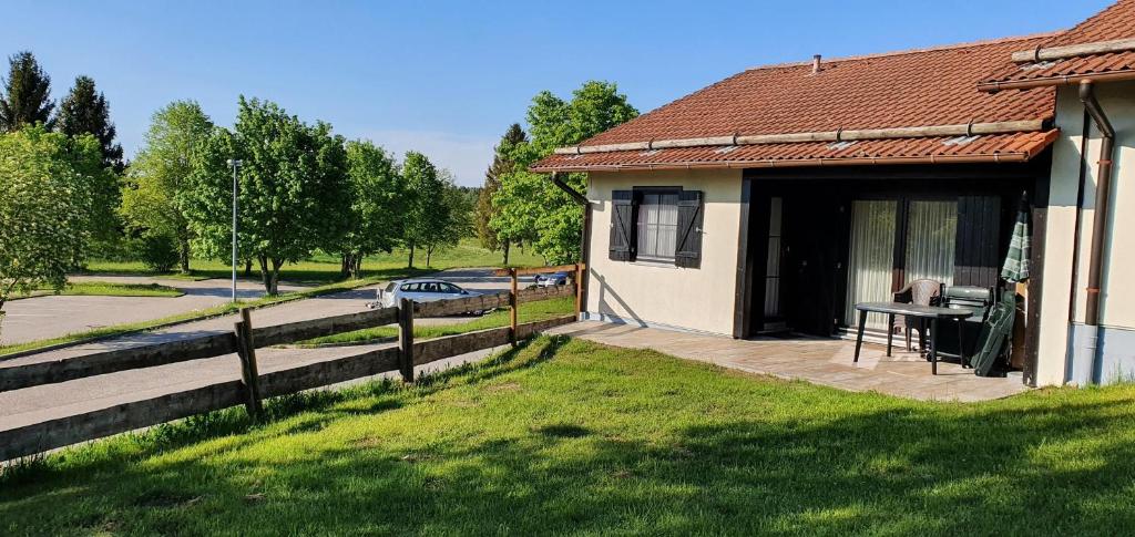 Casa con porche con mesa y valla en Lechbruck am See Feriendorf Hochbergle Haus 1, en Lechbruck