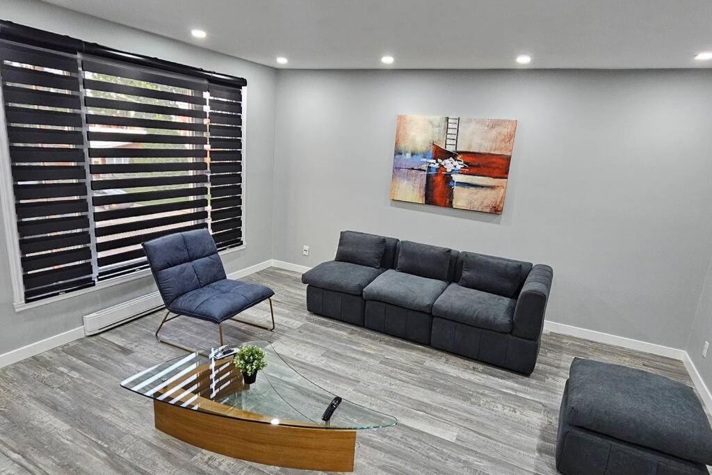 sala de estar con sofá y silla en Spacious bright Apt,Parking and self check-in, en Longueuil