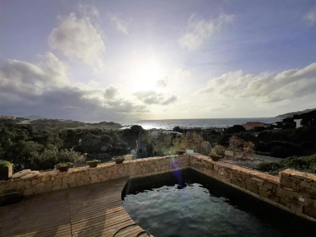 a pool of water on a patio with a view of the ocean at Villa Aphrodite - Baia Santa Reparata in Capo Testa