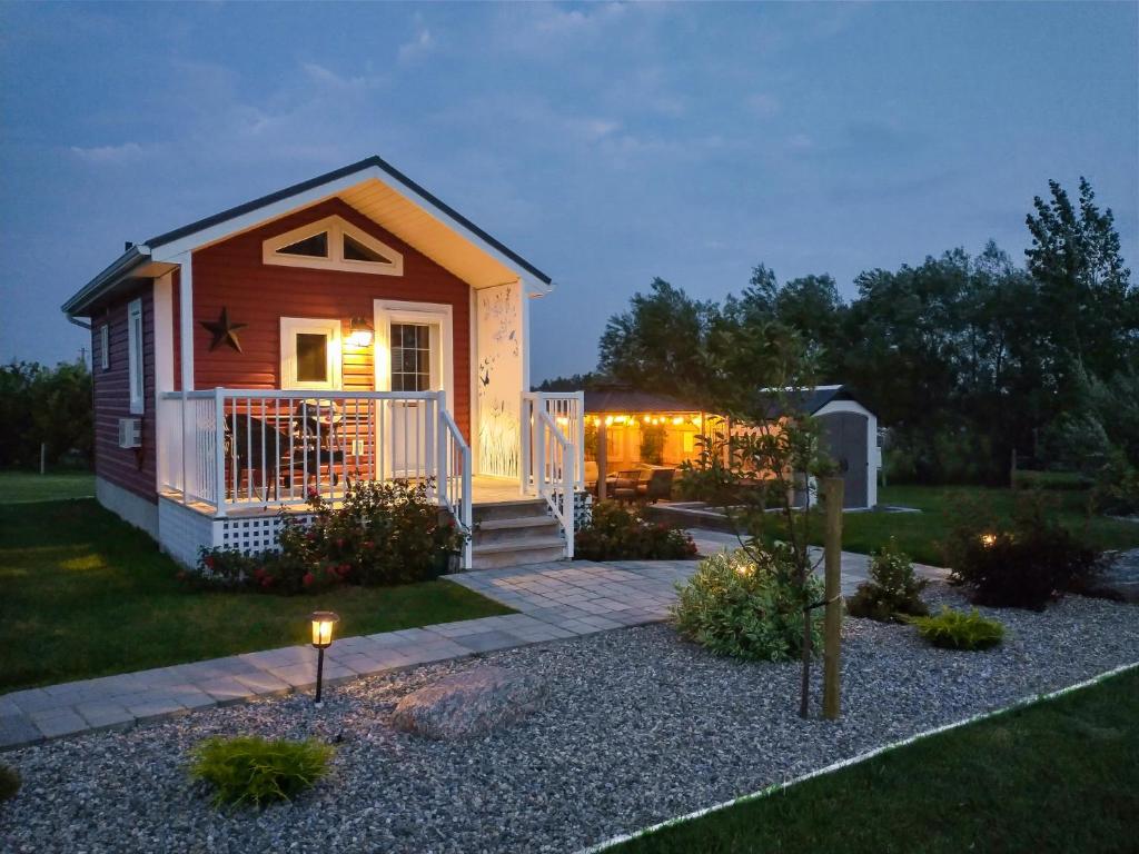 een klein huis met een veranda en een terras bij Prairie Rose Cottage in Fort Macleod