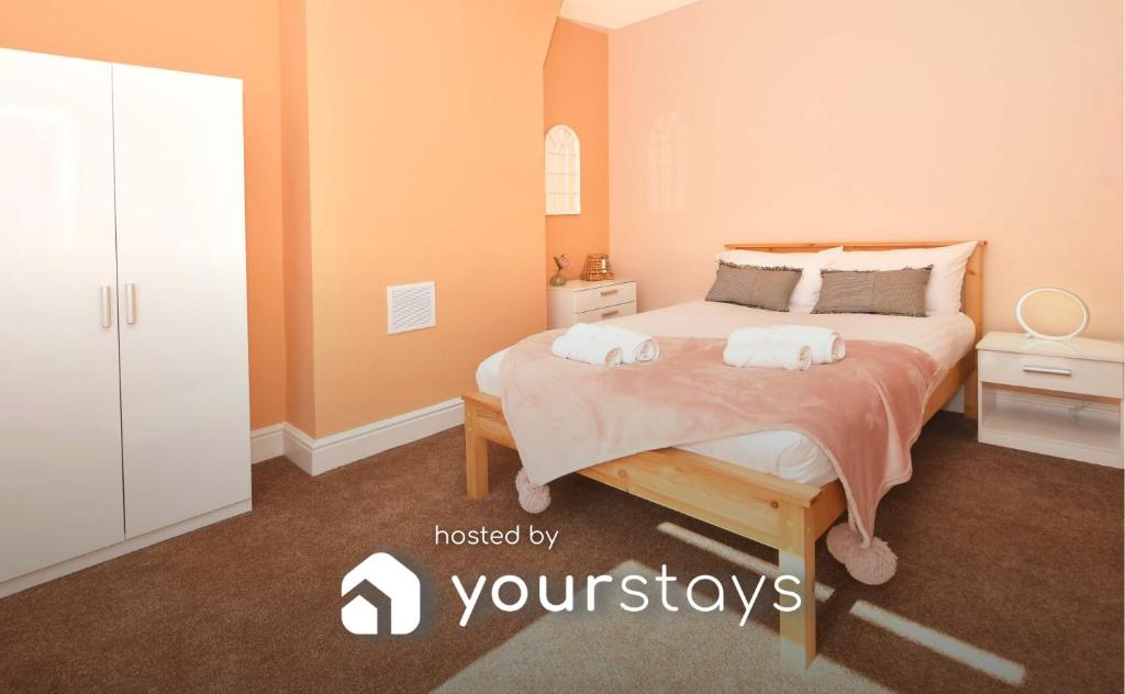 um quarto com uma cama com duas toalhas em All Saints House by YourStays em Stoke on Trent