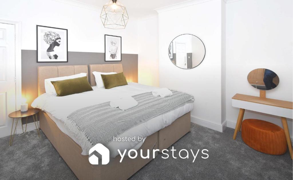 - une chambre avec un grand lit et un miroir dans l'établissement Elm House by YourStays, à Crewe