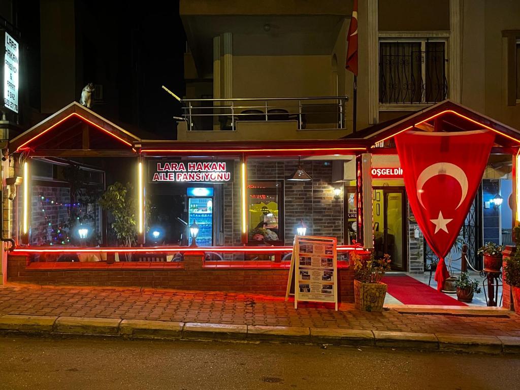 a fast food restaurant with a sign in front of it at night at Lara Hakan Family Apart in Antalya