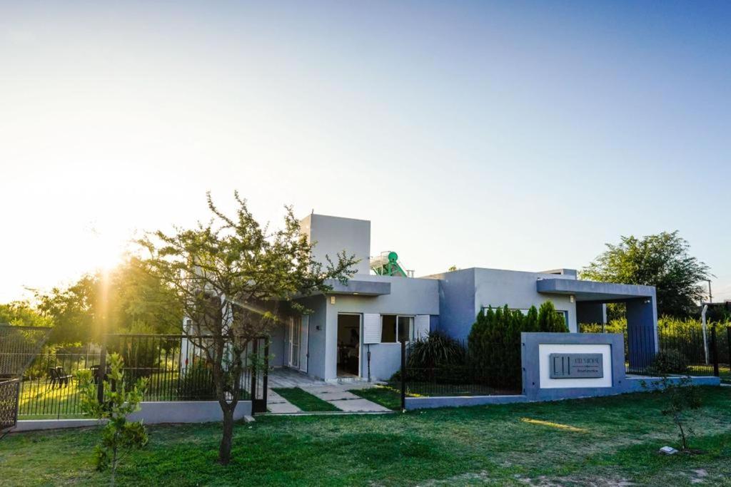 una casa blanca con una valla y un patio en Etels House - Departamentos Mina Clavero en Mina Clavero