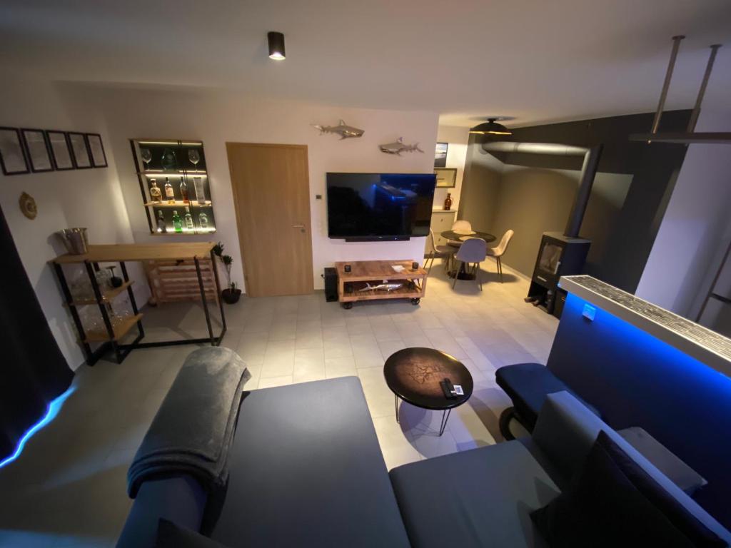 uma sala de estar com um sofá e uma televisão em Stilvolles Apartment - mit E-Auto Lademöglichkeit em Attendorn