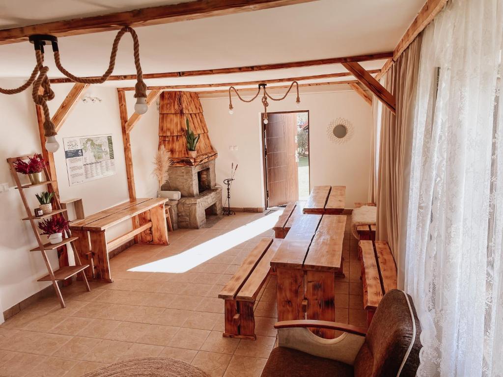 a living room with wooden tables and a fireplace at Koralik - BOHO Apartamenty z BALIĄ w CENIE! Kluszkowce - 1 km od Velo Czorsztyn i CzorsztynSKI in Kluszkowce
