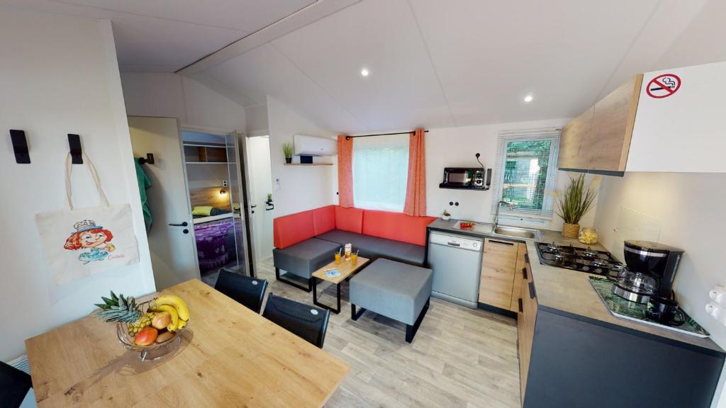 a kitchen with a table with a bowl of fruit on it at Camping Capfun La Bretèche in Les Épesses