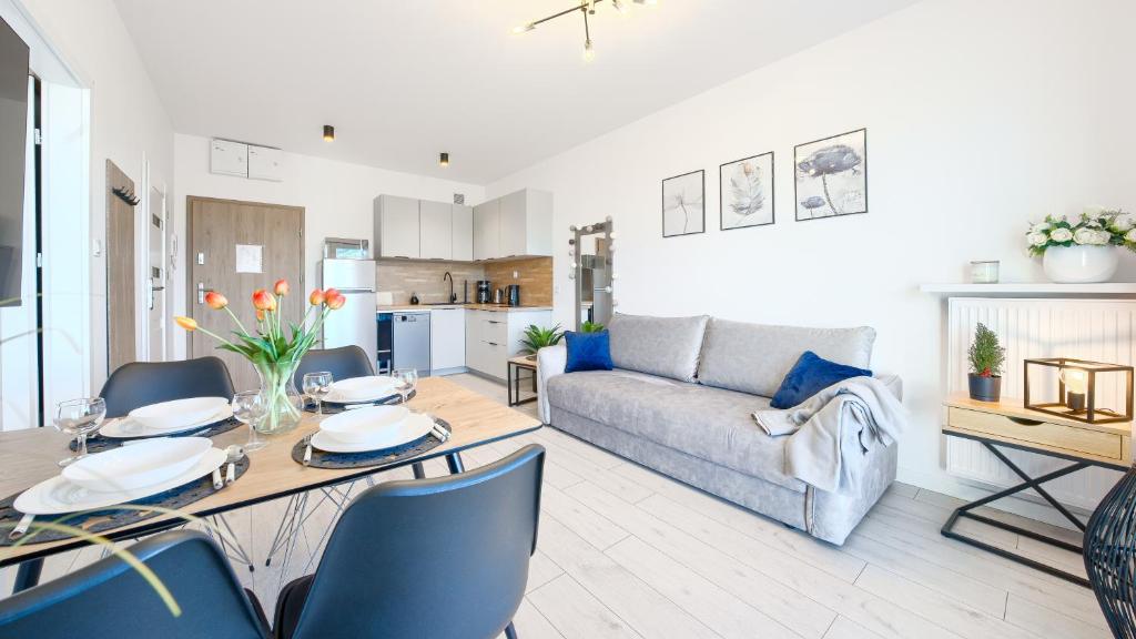 ein Wohnzimmer mit einem Tisch und einem Sofa in der Unterkunft Apartamenty Sun & Snow Pelikan in Rewal