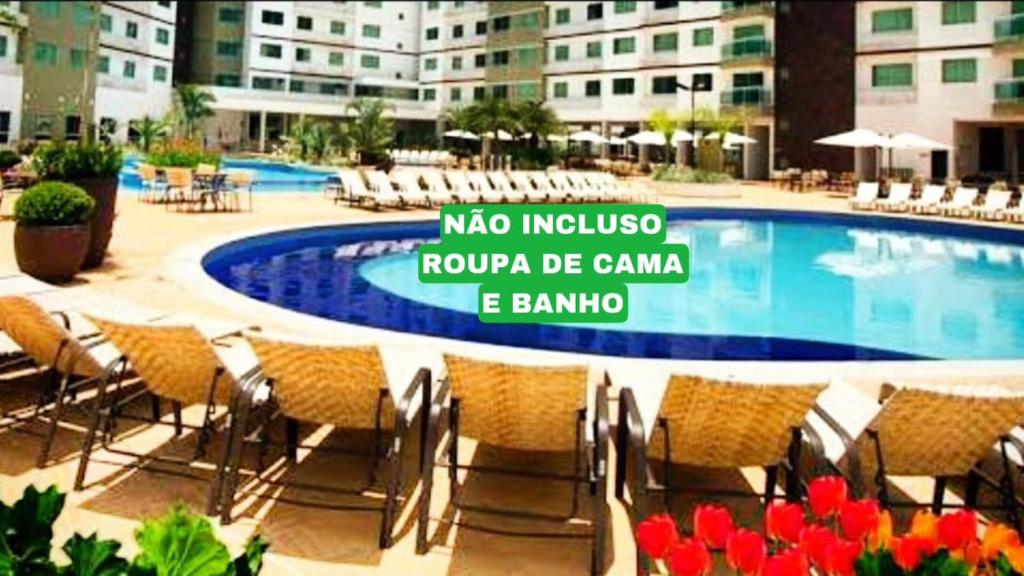 カルダス・ノバスにあるCaldas Novas Rivieraのスイミングプール(椅子付)と建物の前の看板