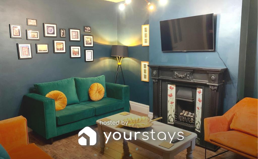 uma sala de estar com um sofá verde e uma televisão em Stamer House by YourStays, Stylish quirky house, with 4 double bedrooms, BOOK NOW! em Stoke-on-Trent