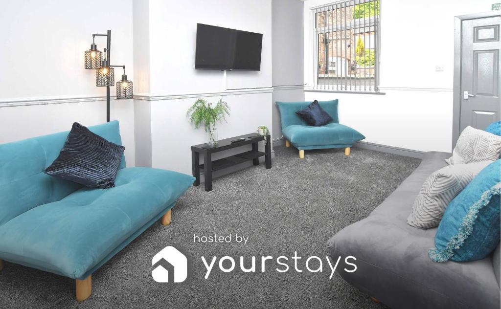 a living room with two blue chairs and a tv at Kings' Terrace by YourStays in Stoke on Trent