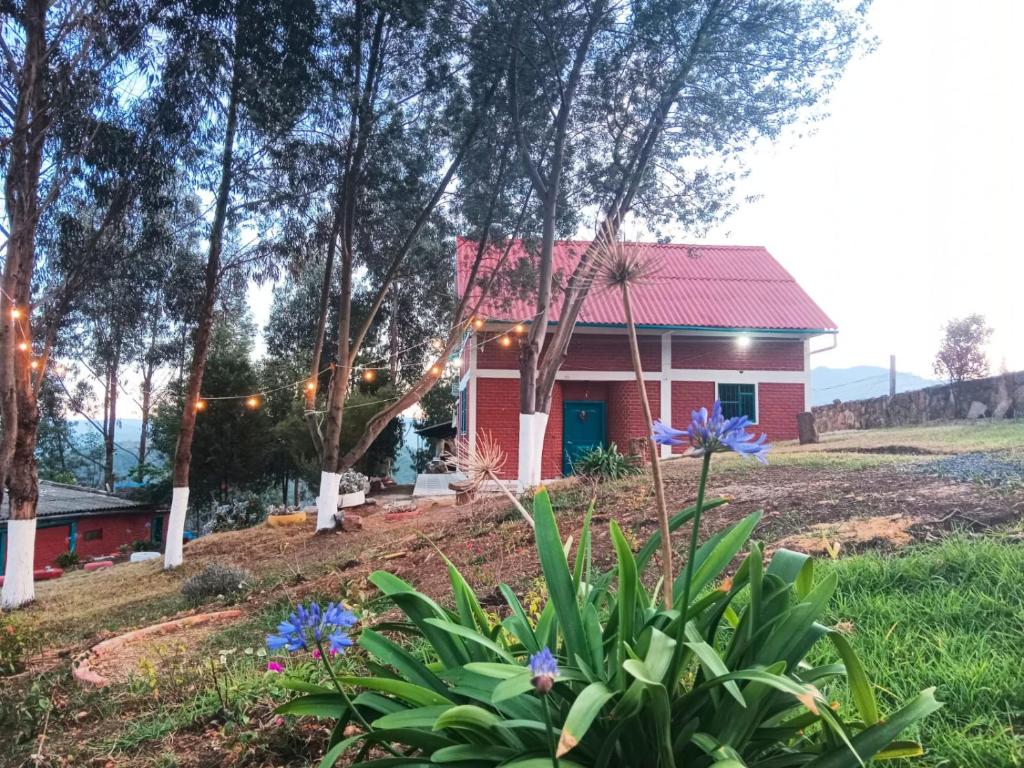 ein kleines rotes Haus mit rotem Dach in der Unterkunft Alojamiento en cabaña in Fúquene