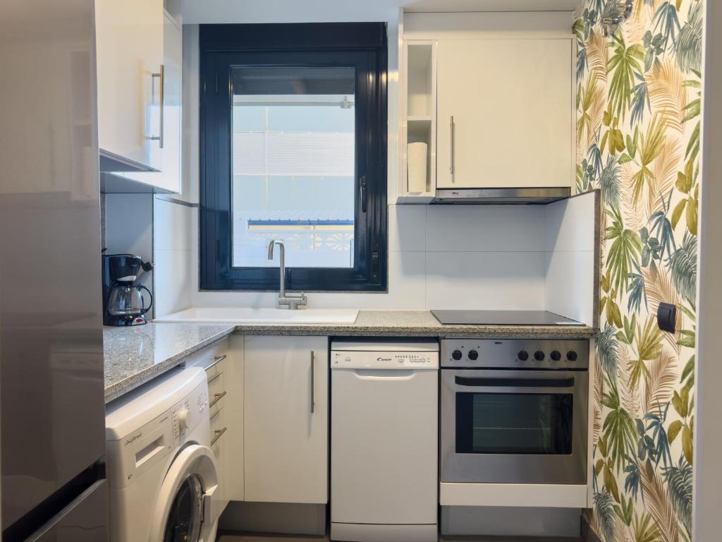Kuchyň nebo kuchyňský kout v ubytování Apartamento con jardín en primera linea de playa con parking y piscina