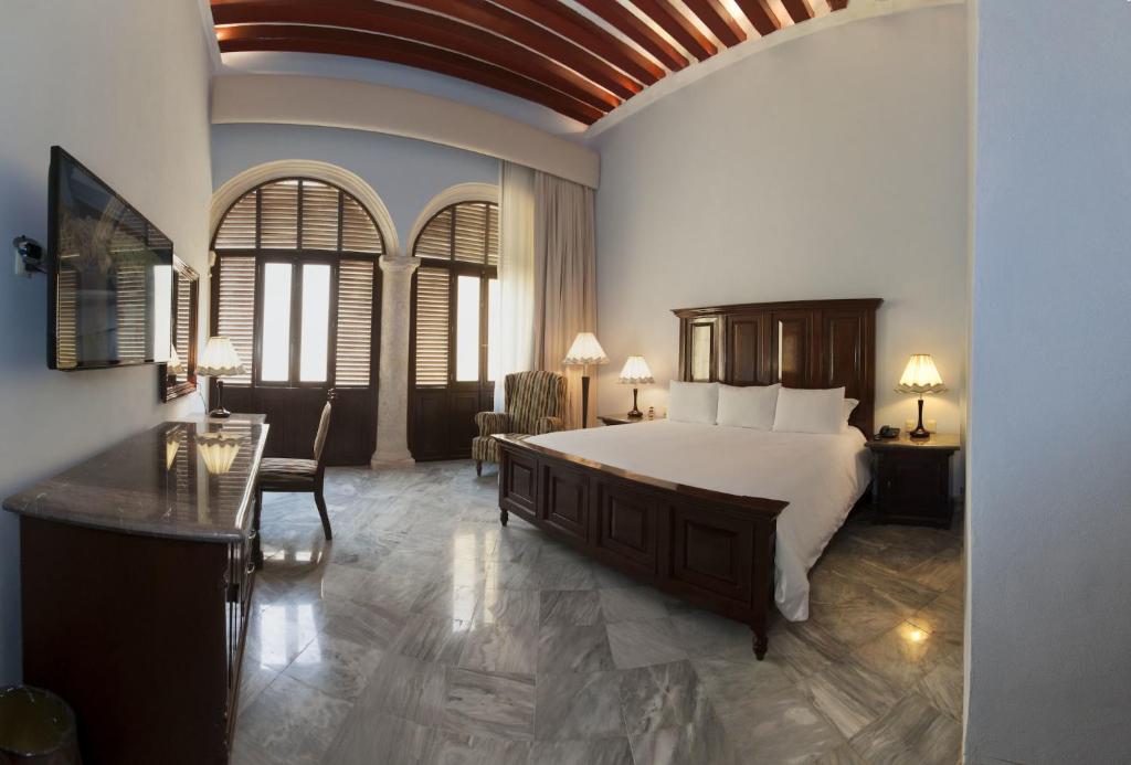 1 dormitorio con 1 cama grande, mesa y sillas en Hotel Lopez Campeche, en Campeche