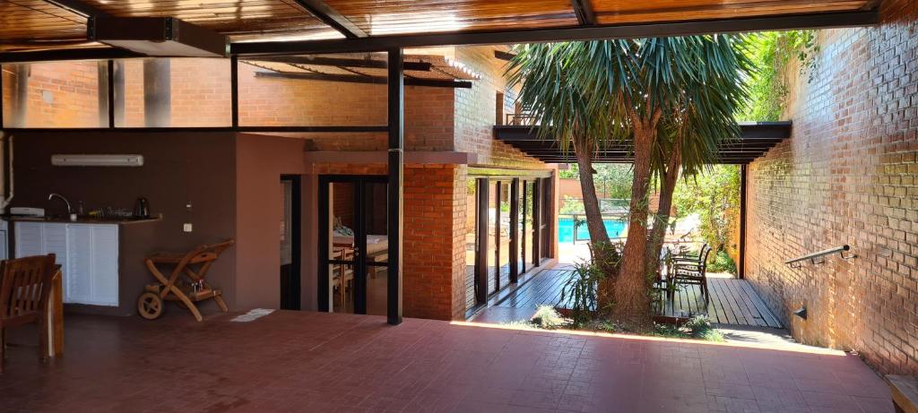 eine offene Terrasse mit einer Palme in einem Gebäude in der Unterkunft Nada de Tucanes. Piscina Loft in Posadas