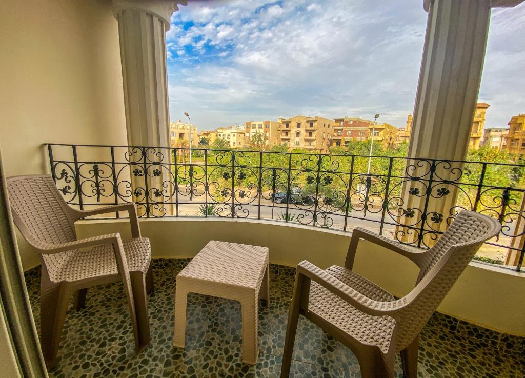 balcón con sillas y vistas a la ciudad en Comfortable 2 BR Apartment in New Cairo's Heart, en El Cairo