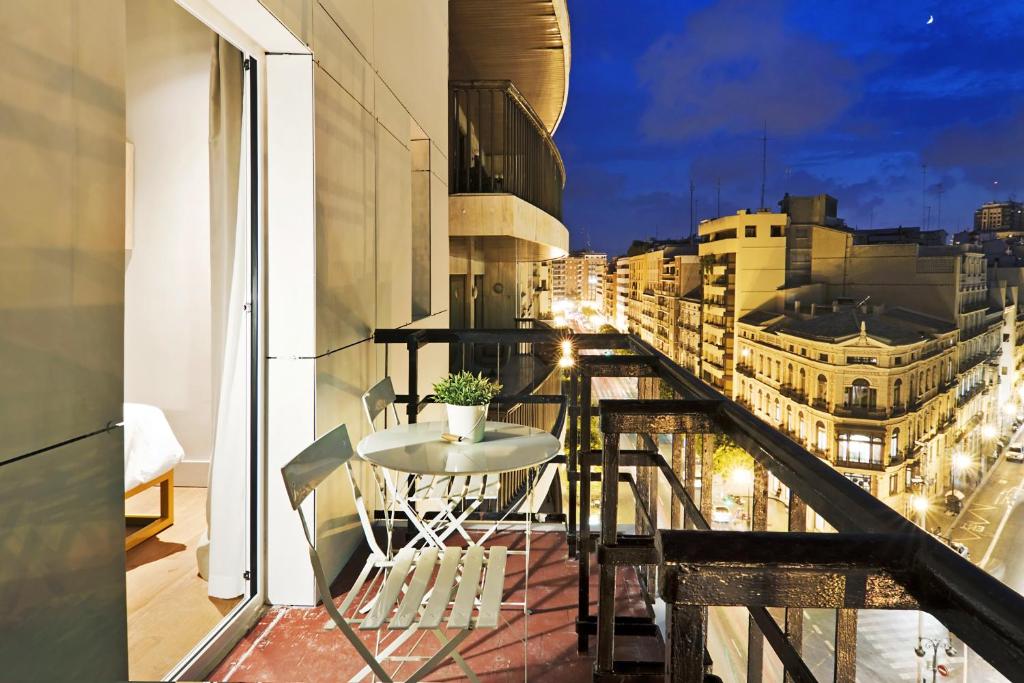 a balcony with a table and a view of a city at One Shot Colón 46 in Valencia