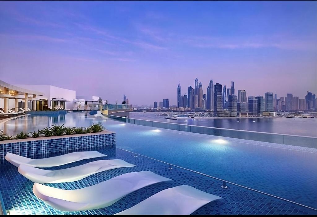 a hotel swimming pool with a view of a city at First Class Apartments in Seven Palm with direct Access to the West Palm Beach and Nakheel Mall in Dubai