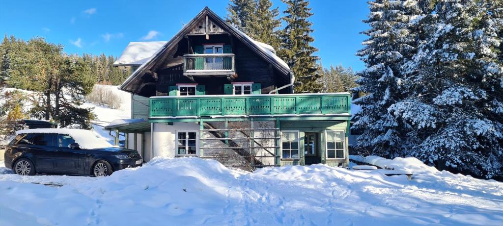 ein Auto, das vor einem Haus im Schnee parkt in der Unterkunft Haus Völlegg in Völlegg