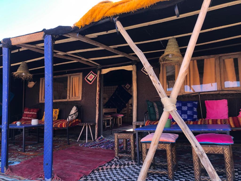 Cette chambre comprend une tente avec des chaises et des tables. dans l'établissement Bivouac Le Petit Prince Merzouga, à Merzouga