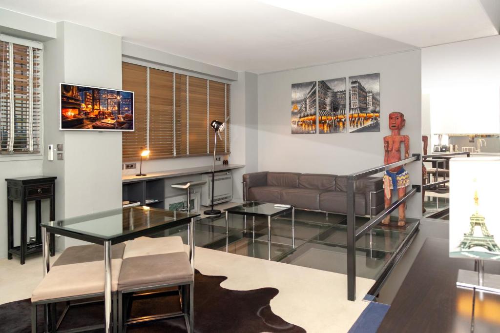 un salon avec une table en verre et un canapé dans l'établissement Loft atypique avec terrasse, calme et cosy, à Paris