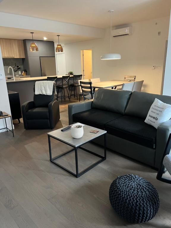 ein Wohnzimmer mit einem Sofa und einem Tisch in der Unterkunft Nouveau Condo Québec in Québec