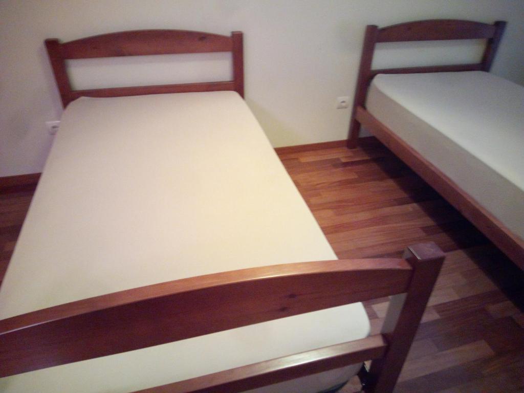 two twin beds in a room with wooden floors at Costa Lodge, private room in Santa Cruz