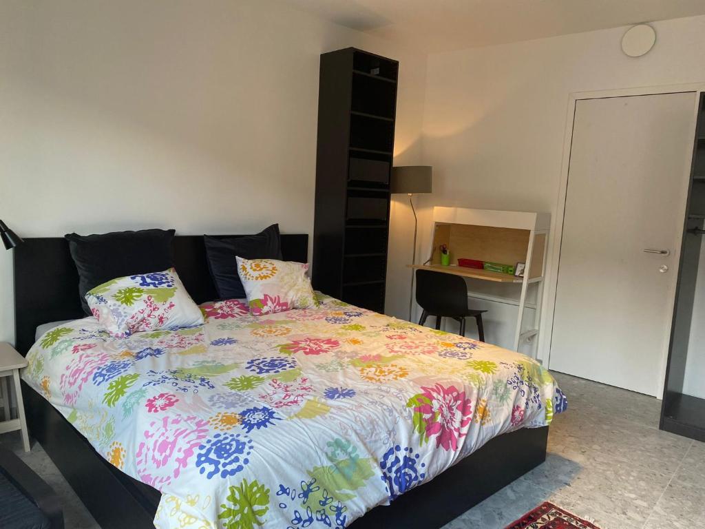 una camera da letto con un letto con un piumone colorato di Central Studio in Kortrijk a Courtrai