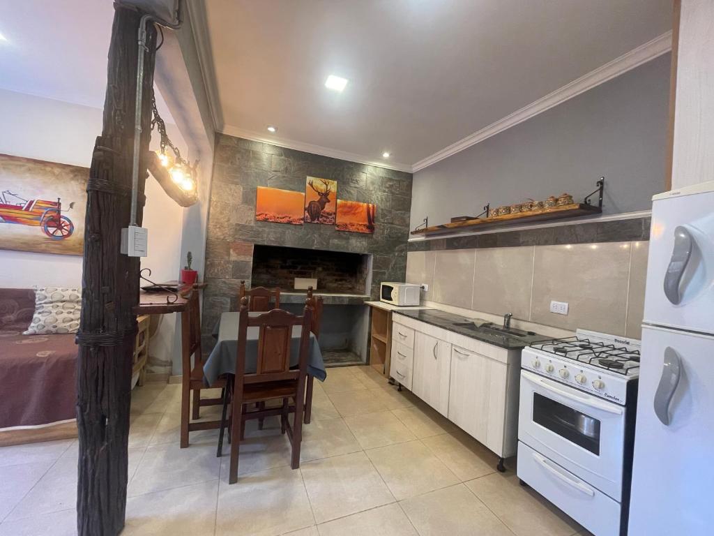 een keuken met een tafel en een fornuis top oven bij Dpto en San Lorenzo in Villa Cura Brochero