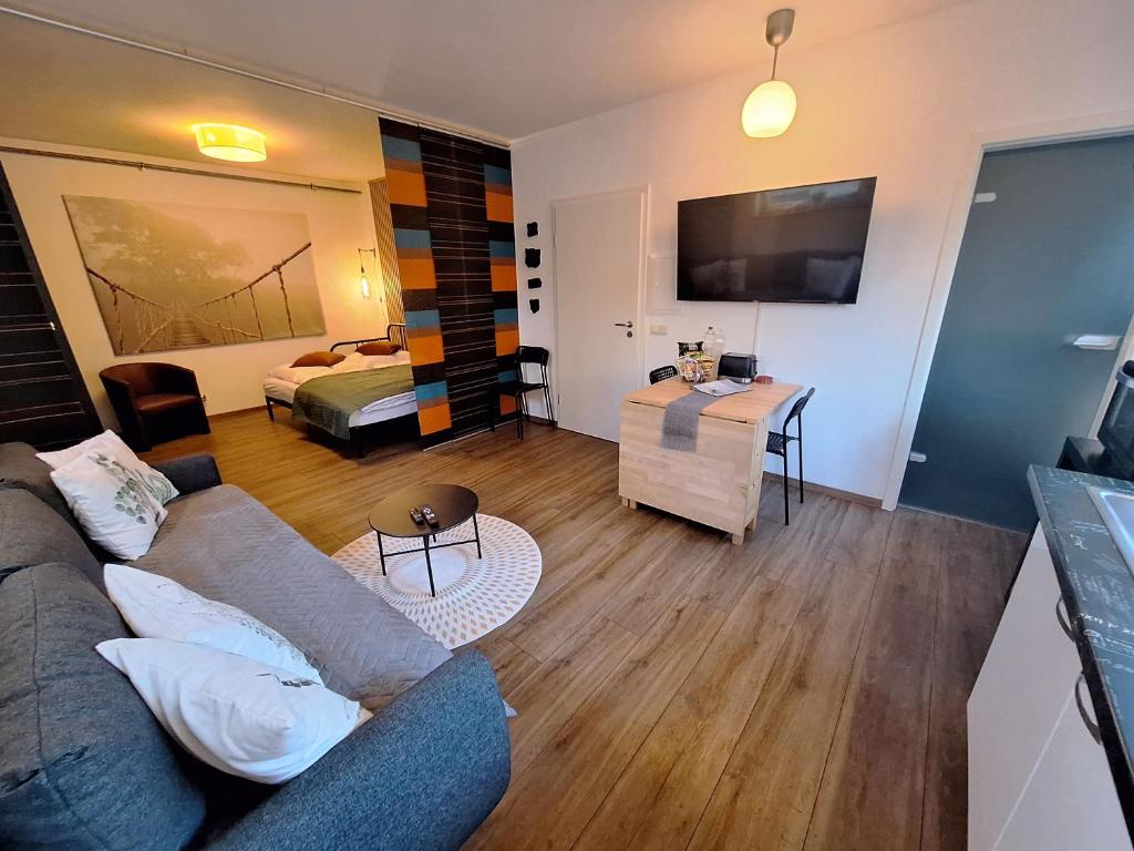 ein Wohnzimmer mit einem Sofa und einem Bett in der Unterkunft Ideal für kurze Aufenthalte – gemütliches 1-Zimmer-Apartment in Adelsdorf
