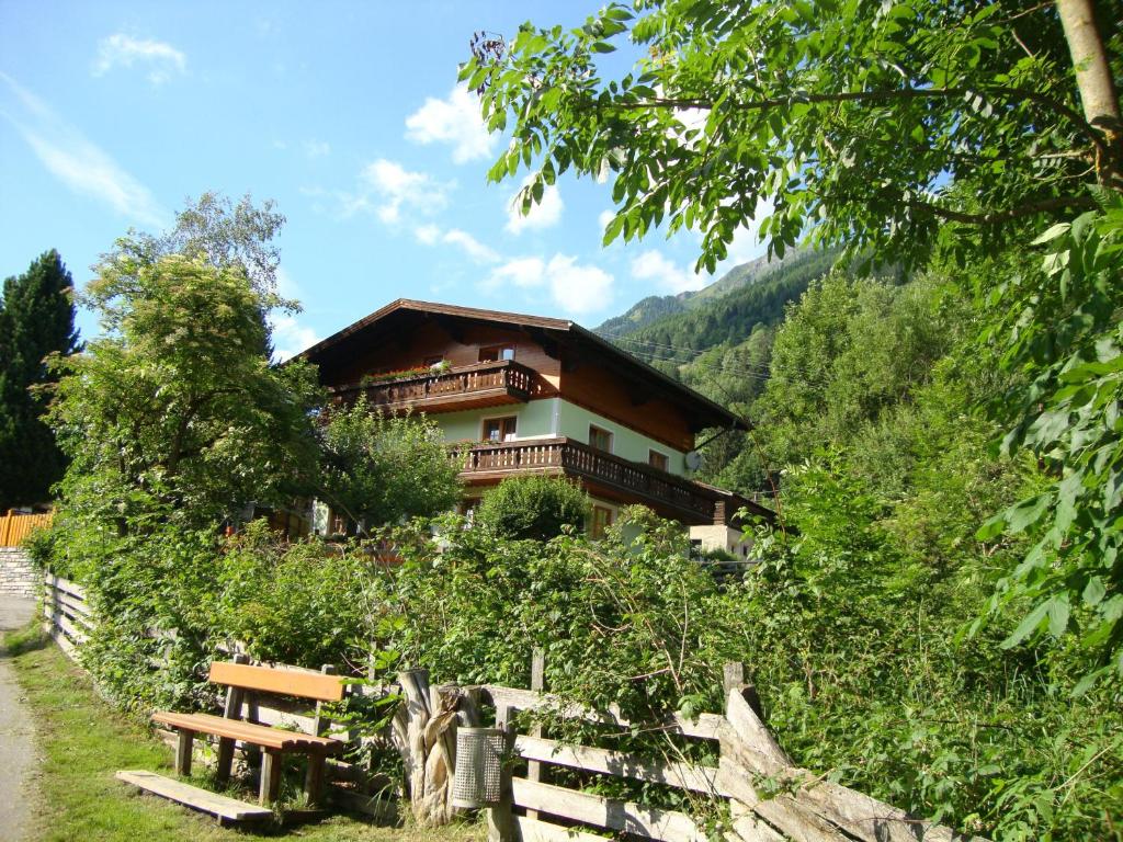 ein Haus an der Seite eines Hügels mit einer Bank in der Unterkunft Gruberbauer Remsach in Bad Gastein