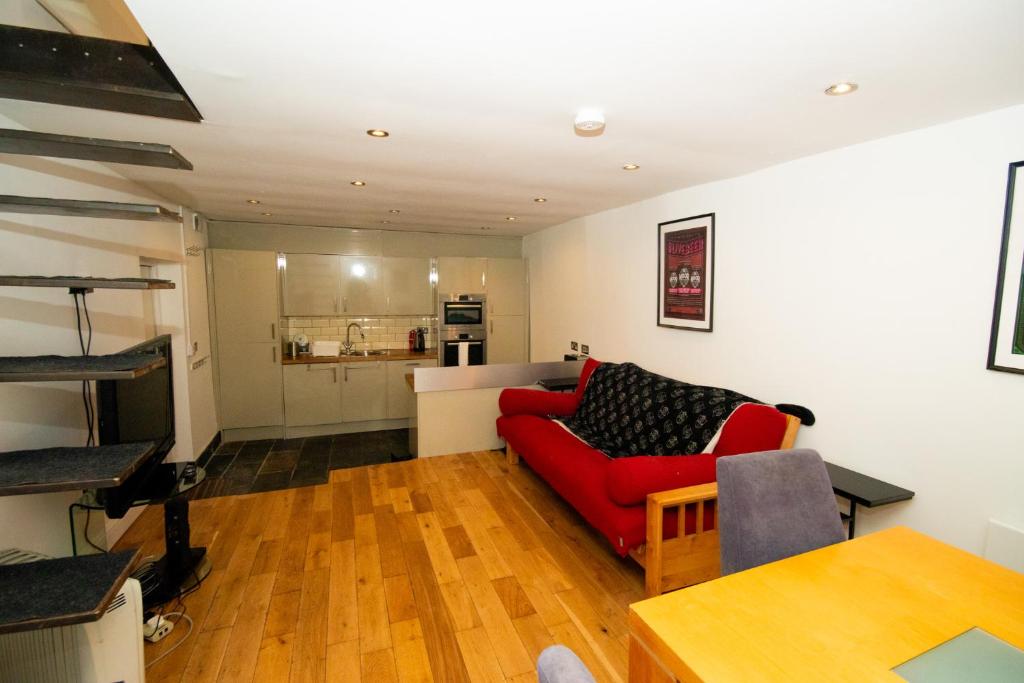 a living room with a red couch and a table at Modern 1-Bed House in Bristol for 4 people in Bristol