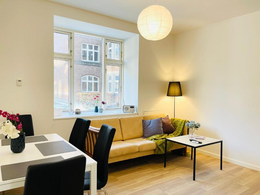 salon z kanapą i stołem w obiekcie Scandinavian Apartment Hotel - Industrimuseet - 3 room apartment w mieście Horsens