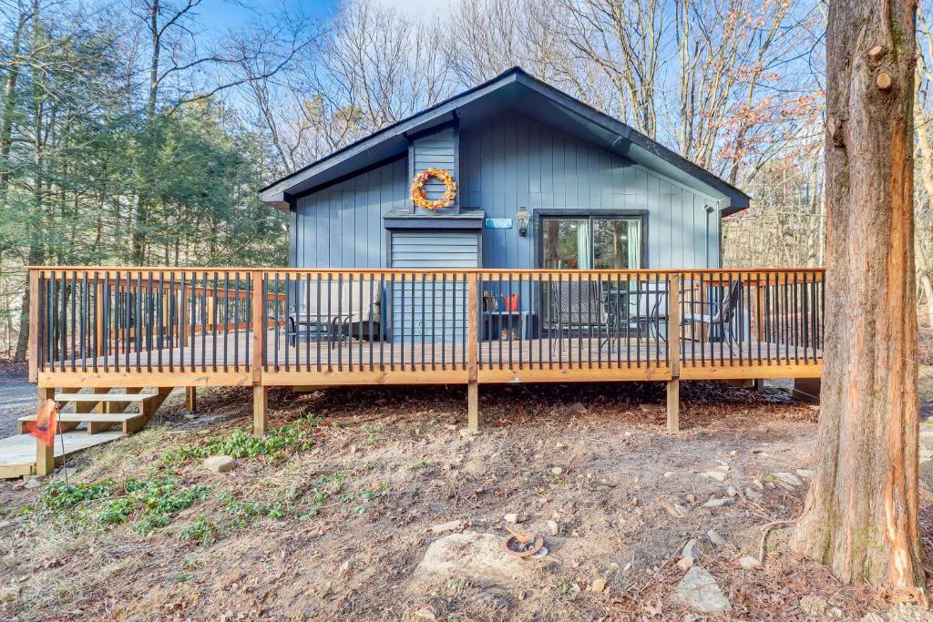 ein kleines blaues Haus mit einer großen Terrasse in der Unterkunft Quaint Jim Thorpe Cabin Retreat, Walk to Beach! in Jim Thorpe