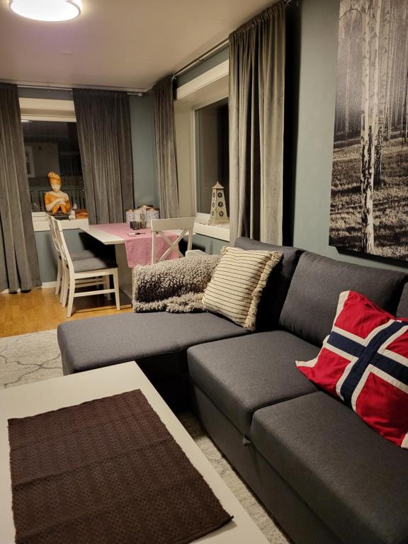 uma sala de estar com um sofá e uma sala de jantar em Ksu Nordlandet leiligheten em Kristiansund