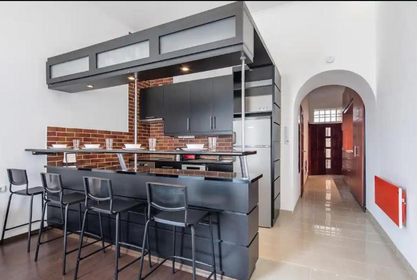 eine Küche mit einer schwarzen Theke und Hockern in der Unterkunft Buda Royal Castle 2 Double Beds Private Apartment in Budapest