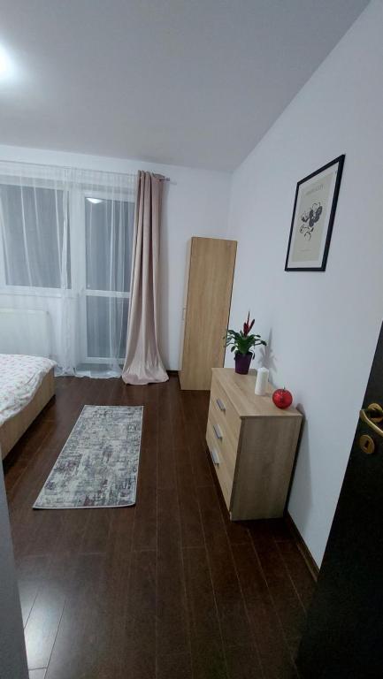 a bedroom with a bed and a dresser in a room at Apartament Râșnov in Râşnov