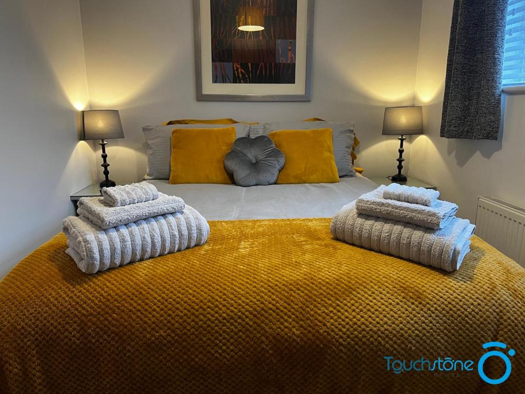 1 dormitorio con 1 cama con toallas en Beautiful Bungalow close to NEC, M42 & Airport, en Sheldon