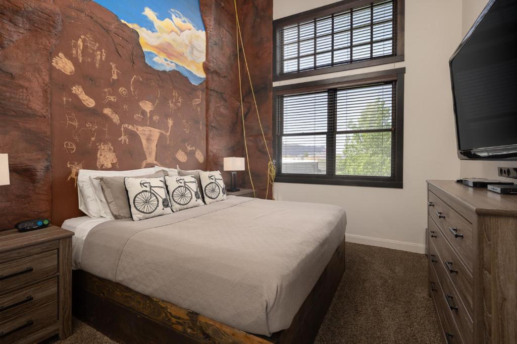 een slaapkamer met een groot bed en een televisie bij Unique Downtown Rental - La Dolce Vita Villas #5 in Moab