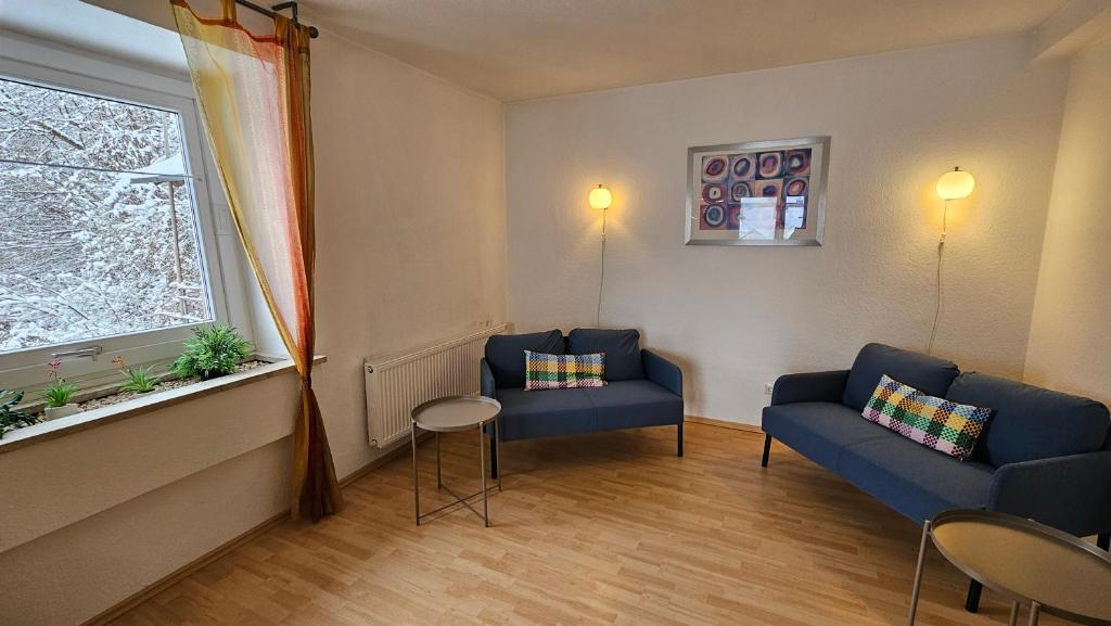 a living room with two blue chairs and a window at Bei München Ferienwohnung in Grafrath "Amperland" in Grafrath