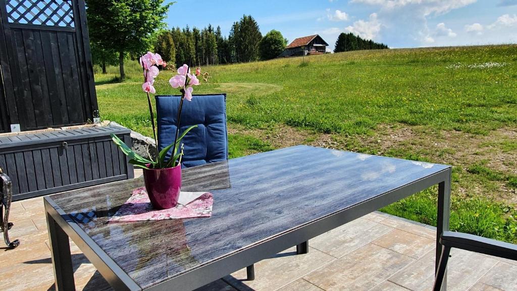 a wooden table with a potted plant on a patio at Lechbruck am See Feriendorf Hochbergle Haus 116 in Lechbruck
